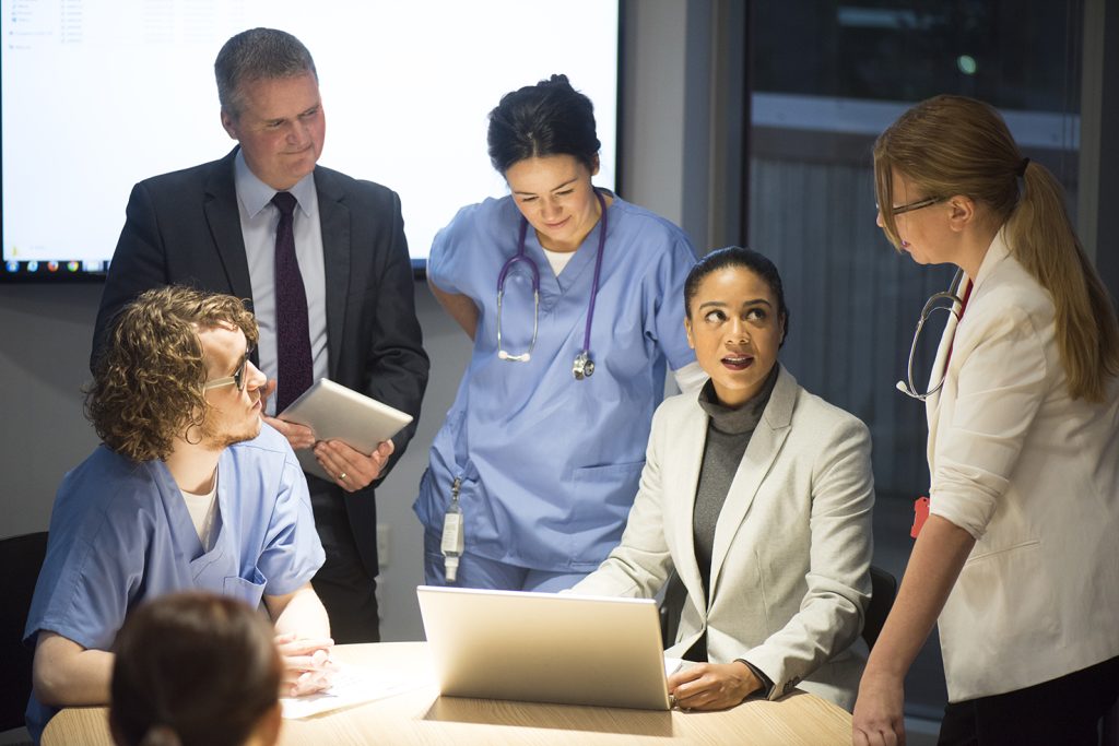 Professionnels du secteur de la santé en réunion autour d’un ordinateur.